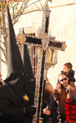 penitentes port a cross on Viernes de Pasion in Cadiz